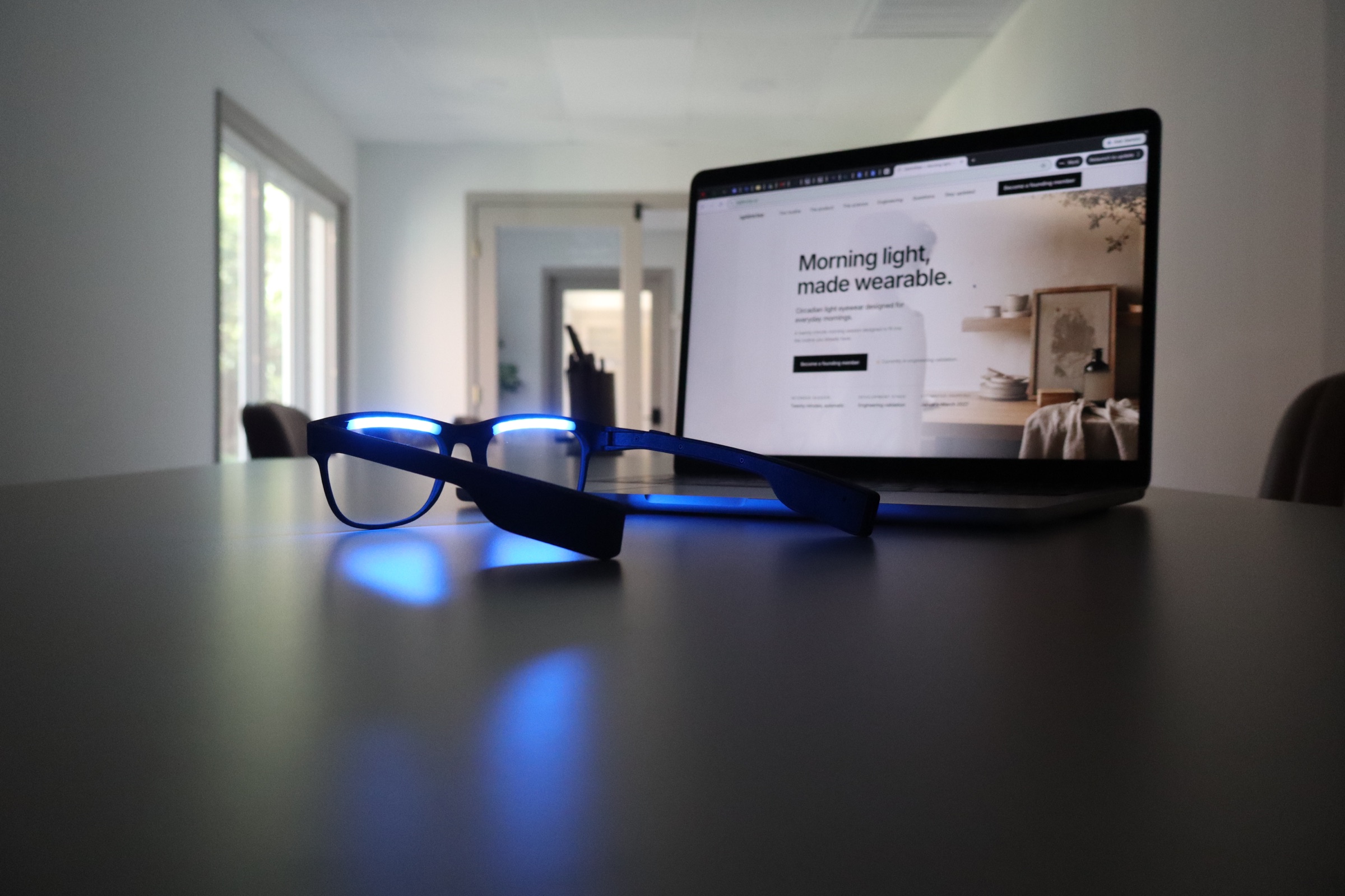 A powered-on OptimRise engineering-validation prototype in front of a laptop displaying the OptimRise website.