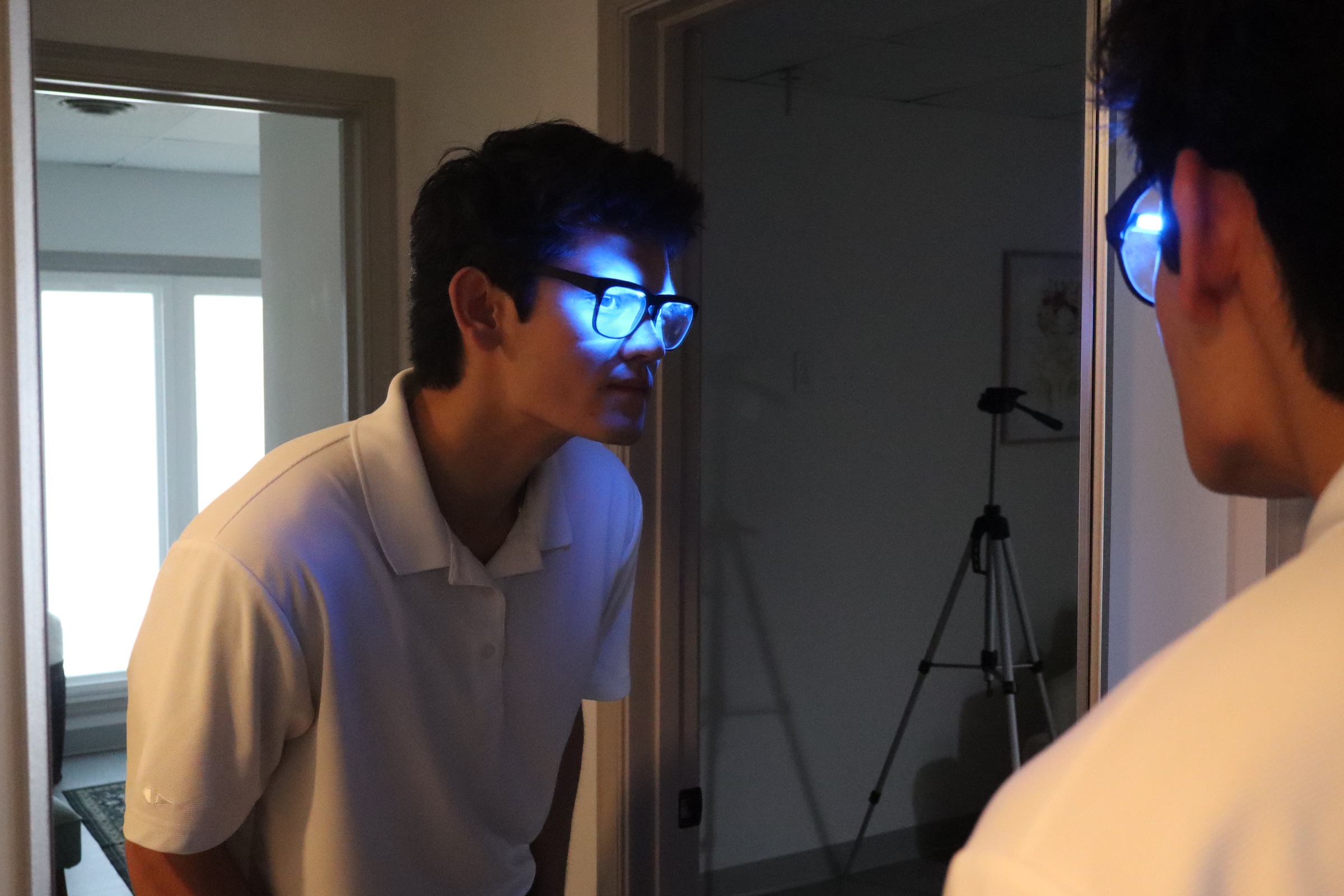 A person checking the fit of a powered-on OptimRise engineering-validation prototype in a mirror.
