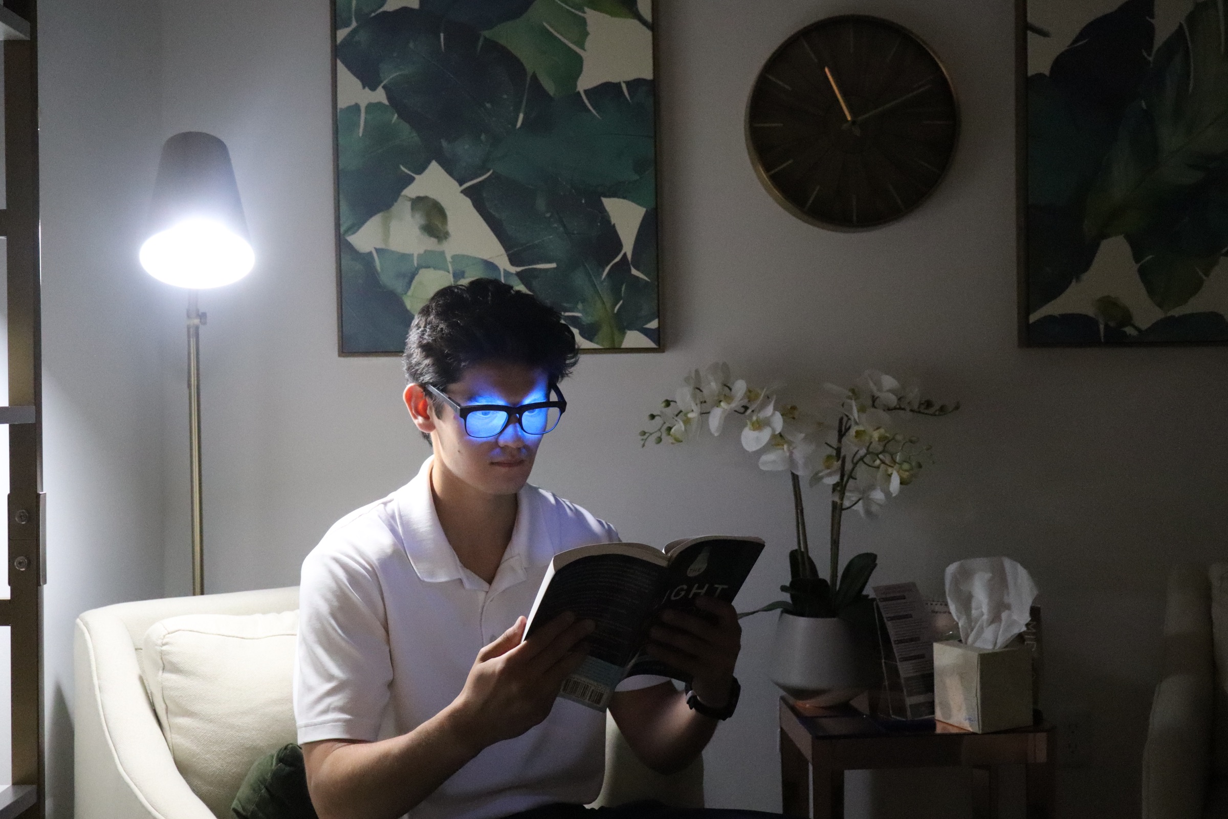 A person reading indoors while wearing a powered-on OptimRise engineering-validation prototype.